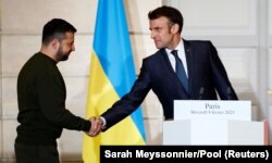 Президент Украины Владимир Зеленский (слева) и президент Франции Эмманюэль Макрон пожали друг другу руки во время совместного заявления с канцлером Германии Олафом Шольцем. Париж, 8 февраля 2023 года