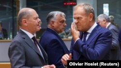 Almaniya kansleri Olaf Şolts və Polşanın baş naziri Donald Tusk Aİ sammitində. Arxa planda (ortada) Macarıstanın baş naziri Viktor Orban