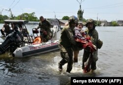 Украинские военнослужащие эвакуируют местных жителей из затопленной зоны в Херсоне после прорыва Каховской ГЭС. Украина, 8 июня 2023 года