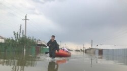 Спасатели помогают жителям Оргебаса добраться к домам на лодке, чтобы забрать документы.