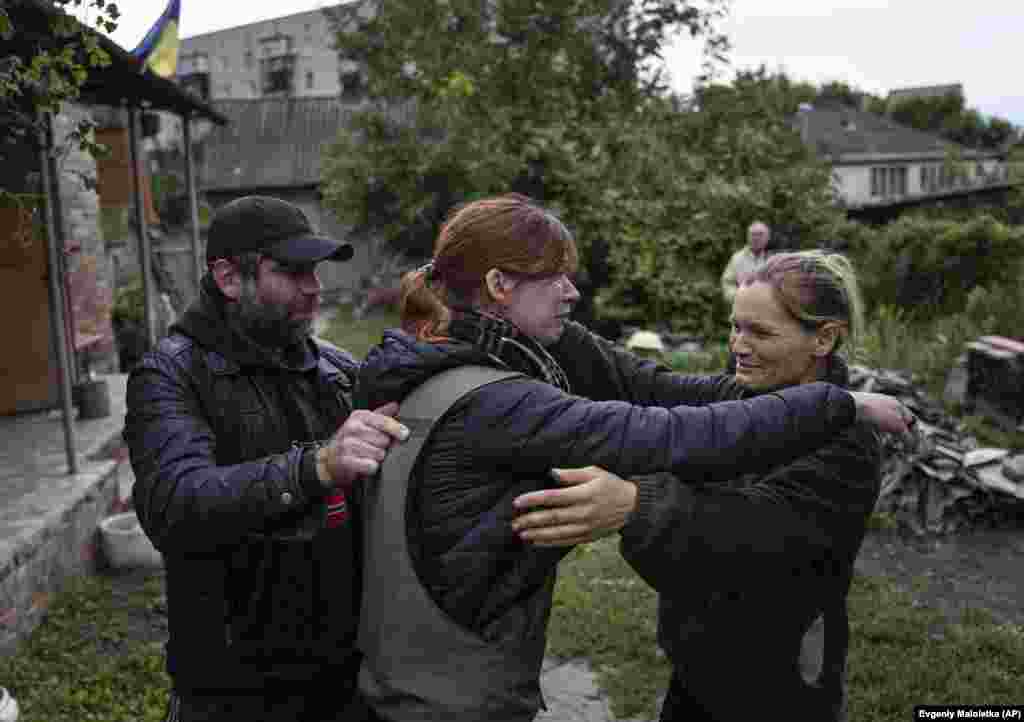 Мария (в центре) обнимает своих родителей Марину и Александра в недавно освобожденном городе Изюм. Девушка не видела родителей с начала оккупации