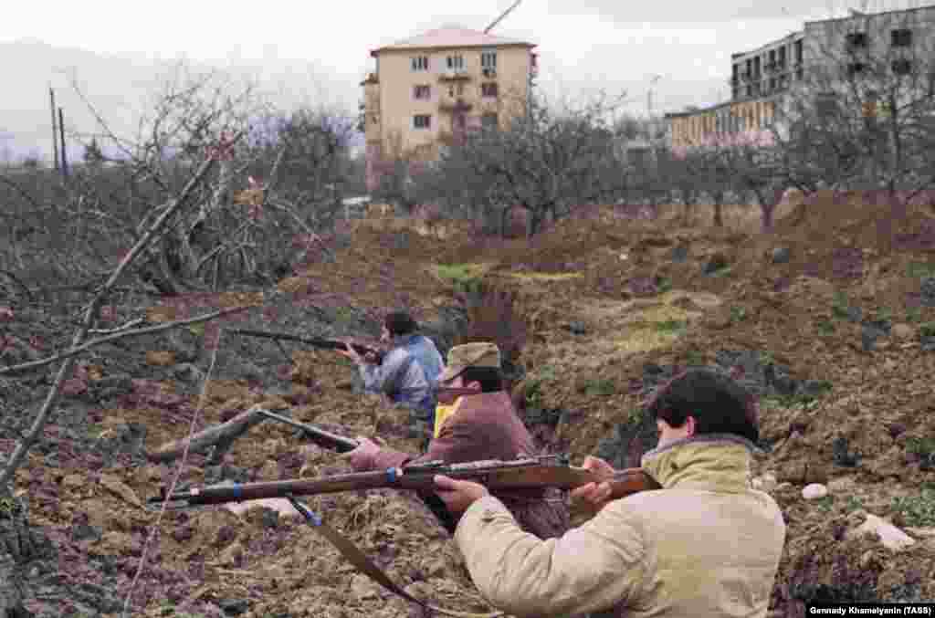 Цхинвалдың сыртындағы траншеяда тұрған осетиндер. Олар өндірісі 1890-жылдары басталған Мосин-Наган дейтін ескі орыс мылтығын ұстап тұр. 1991 жылы Оңтүстік Осетиядағы грузин және осетин ауылдарында ұлтаралық қырғын, қоқан-лоқы жиі байқалды.