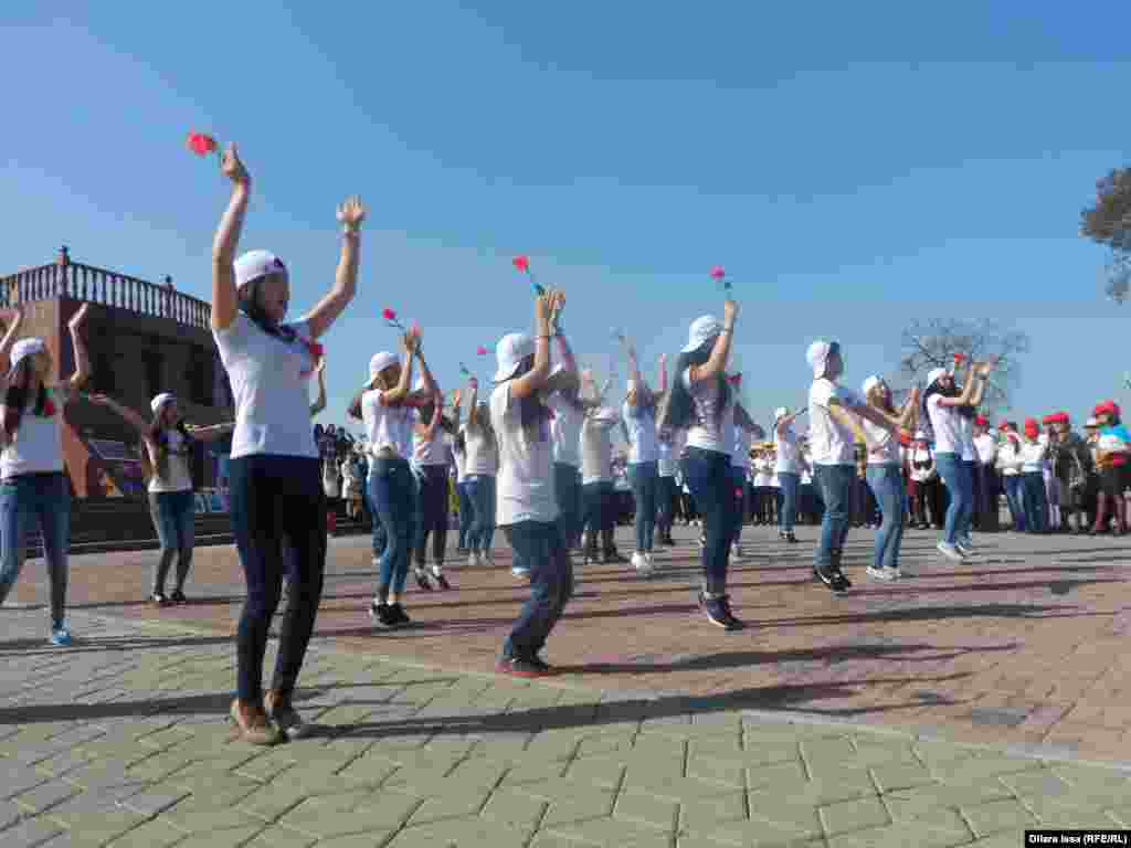 Қызғалдақ мерекесінде өнер көрсетіп тұрған жастар.