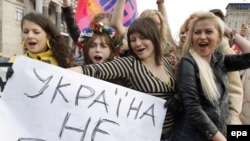 Участницы женского движения Femen держат плакат с надписью «Украина не бордель!» во время своего протеста в центре Киева. 18 октября 2009 года.