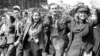 UK -- happy group marches down a London street on VE Day.