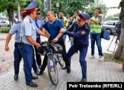 Полиция велосипедпен кетіп бара жатқан адамды ұстап жатыр. Алматы, 10 маусым 2019 жыл.