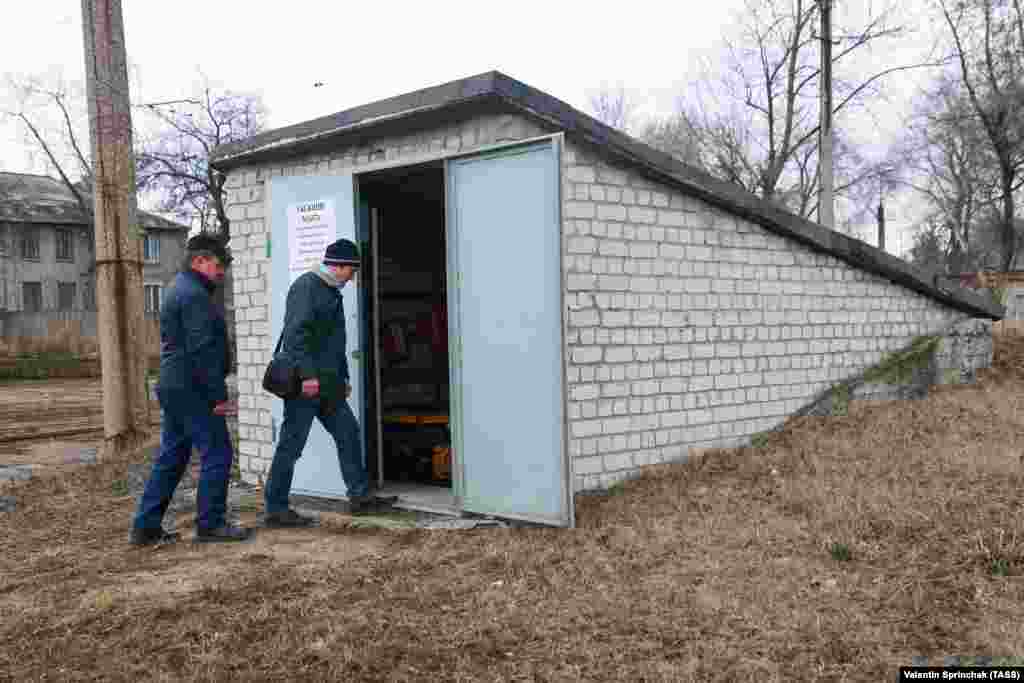 Чоловіки заходять у бомбосховище у трамвайному депо в Донецькій області в районі, контрольованому російськими гібридними силами, 24 березня