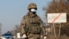 KAZAKHSTAN -- A Kazakh serviceman wearing a protective mask stands guard at a check point, following the state emergency commission's decision to lock down Almaty to prevent the spread of coronavirus disease (COVID-19), on the outskirts of Almaty, Kazakhs