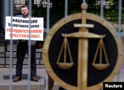 Мужчины у здания суда в Москве проводит акцию в поддержку подсудимых по "Болотному делу". 6 июня 2013 года. Иллюстративное фото.