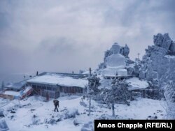 Буддист несет дрова мимо главного здания монастыря Шад Тчуп Линг, построенного на оказавшейся в центре спора земле. Декабрь 2016 года.