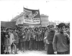 Митинг в Петербурге, люди стоят с плакатом: «Трепещите, польские паны. Питерские коммунисты отправляются на польский фронт».