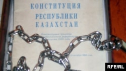 Конституция и цепи, которые активисты партии «Азат» отправили профессору из Актобе Закратдину Байдосову в знак протеста против идеи пожизненного президентства Нурсултана Назарбаева. Талдыкорган, сентябрь 2009 года. (Иллюстративное фото.)