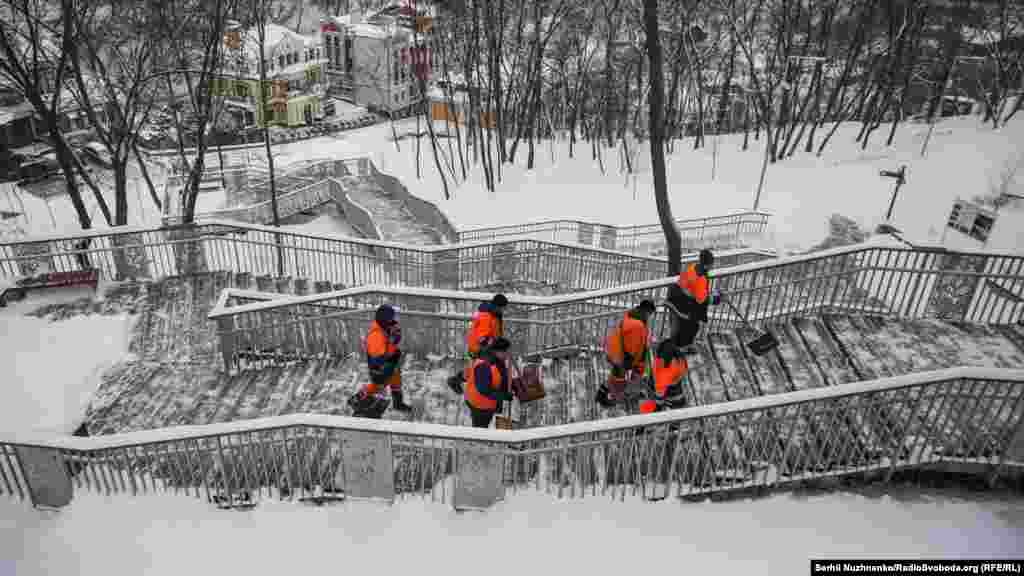 Комунальники йдуть сходами із Пейзажної алеї на Поділ 