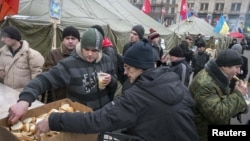 Тәуелсіздік алаңында билікке наразылық шеруіне қатысушылар тегін тамақпен жүрек жалғап тұр. Киев, 20 желтоқсан 2013 жыл.