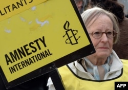 Amnesty International ұйымының мүшесі акция өткізіп тұр. (Көрнекі сурет)