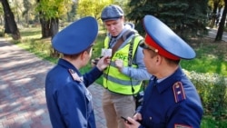 Полицейлер наразылық акциясы өтеді деп алдын ала хабарланған жерге келген журналистің құжатын тексеріп тұр. Алматы, 26 қазан 2019 жыл.