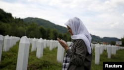 Хажра Чатич күйеуінің сүйегі жерленген зиратта құран бағыштап тұр. Потокари, Сребреница. 10 маусым 2015 жыл.