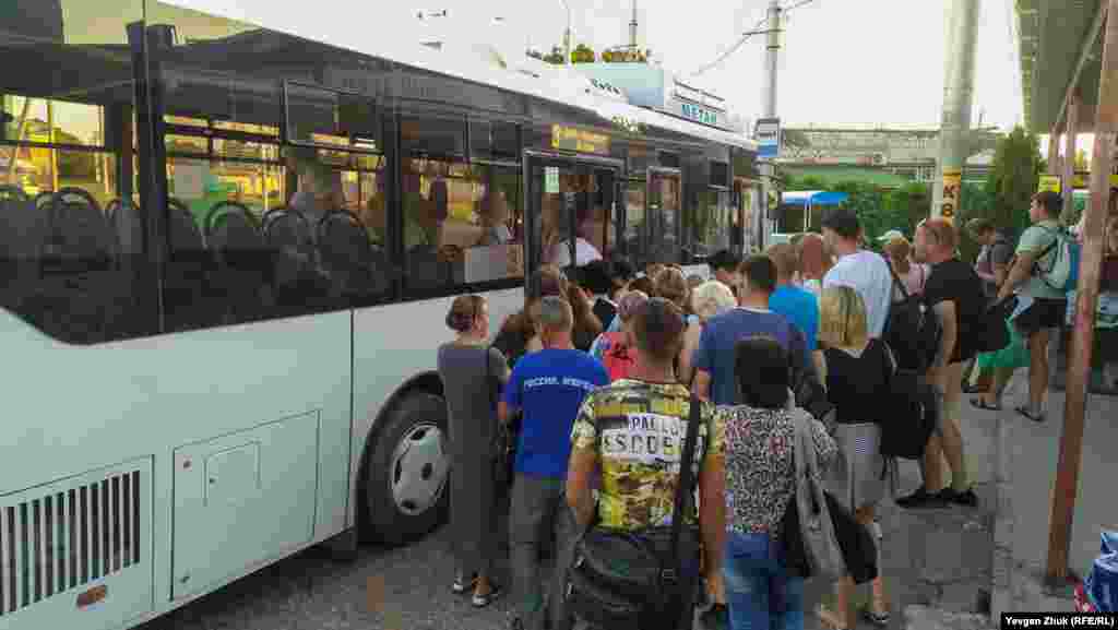 На входе в автобус люди толпятся, не соблюдая социальную дистанцию