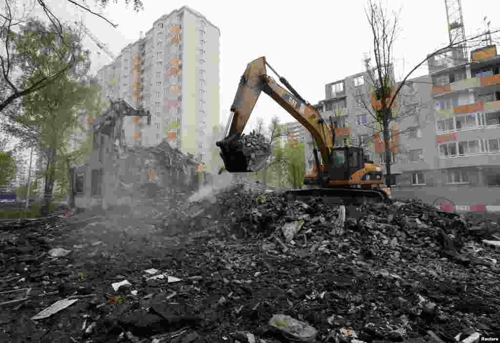 Экскаватор работает на месте снесенного дома советской эпохи. Москва, 16 мая 2017 года.