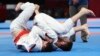 Indonesia Asian Games Ju-Jitsu-Ruslan Israilov of Kazakhstan, right, competes against Nursultan Alymkulov of Kyrgyzstan, left, during Newaza men -77 kg Ju-Jitsu final match at the 18th Asian Games in Jakarta, Indonesia, Sunday, Aug. 26, 2018. (AP Photo/Ac